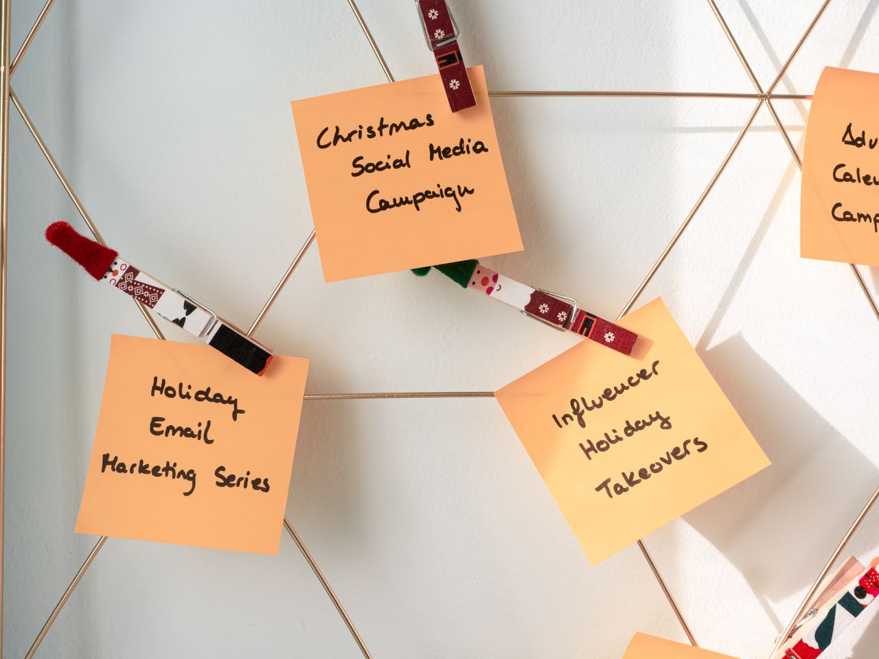 Des notes adhésives avec des idées de marketing de fêtes pour les campagnes de Noël sur les réseaux sociaux et par e-mail.